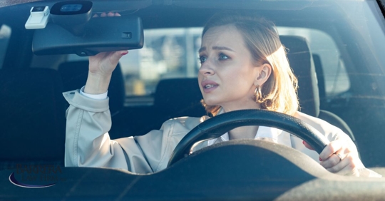 Woman checking rear-view mirror anxiously